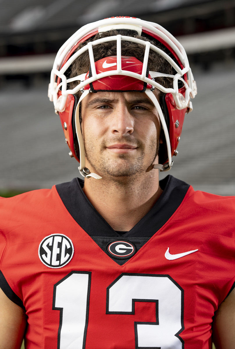 Stetson Bennett looks into camera with his helmet half on.
